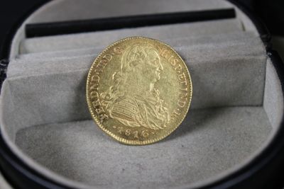 une pièce d'or posée dans un écrin sur une table
