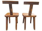two wooden chairs sitting next to each other on a white surface