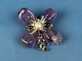 an image of a purple flower broochle with a pearl center