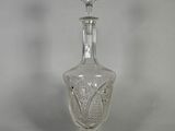 une carafe ancienne en cristal taillé, ornée d'un oiseau sur le bouchon