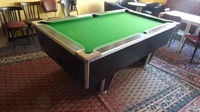 a pool table in the middle of a room with chairs