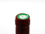 a bottle of red wine with a green label on it