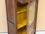 a wooden cabinet with a yellow door and shelves