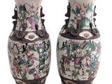 pair of chinese vases with figures and flowers on them