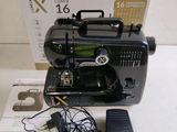 a black sewing machine sitting on a table next to a box
