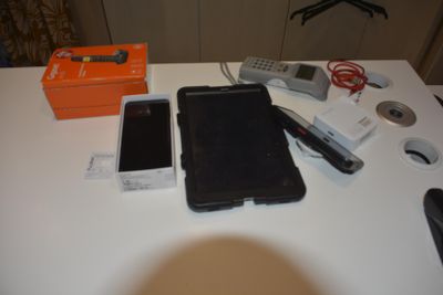 a table with a cell phone and other electronics on it
