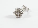 a close up of a pair of diamond stud earrings on a white surface
