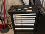 a black tool box with tools on it in a garage