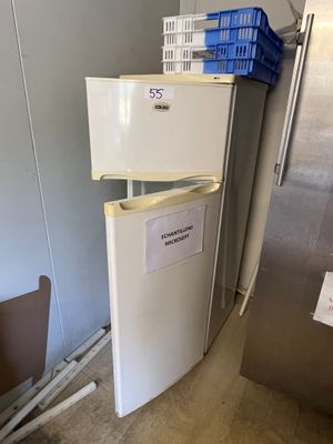 un réfrigérateur qui se trouve dans le coin d'une pièce