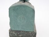 statue of a woman holding a bird on a rock