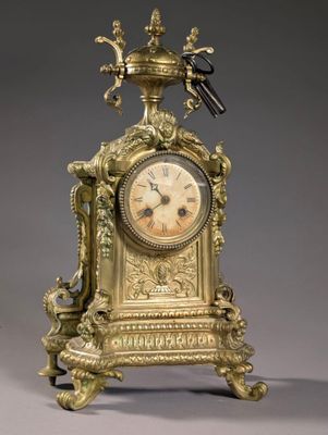 une horloge en or surmontée d'un oiseau
