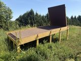 a wooden bench in the middle of a grassy field