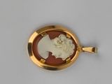 an image of a gold and red cameo pendant with a woman ' s face