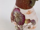 a small vase with a flower on it sitting on a table