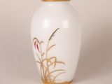 a white vase with a gold rim and flowers on it