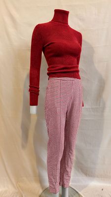 a mannequin of a woman wearing a red sweater and checkered pants