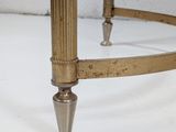an antique brass coffee table with a glass top on a white surface