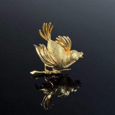 an image of a gold bird sitting on top of a black surface