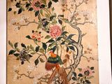 une image représentant une peinture d'un oiseau et de fleurs accrochée au mur