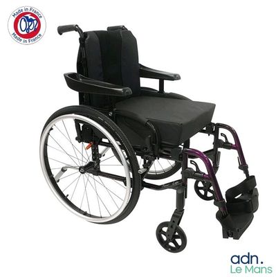 Le fauteuil roulant est noir et possède un siège et un repose-pieds violets.