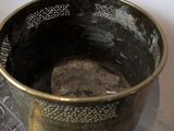 a metal container with a rock in it on a table