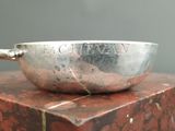 a silver bowl sitting on top of a red marble block