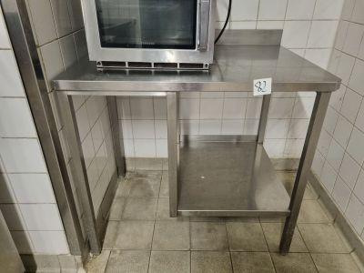 a microwave sitting on top of a stainless steel table