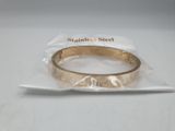 a gold ring on a plastic bag on a white surface
