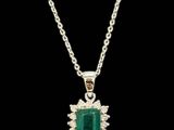 an emerald and diamond pendant on a chain