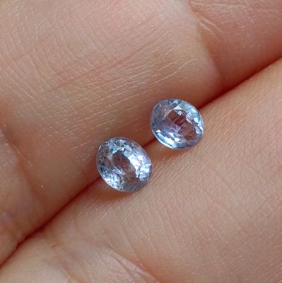 someone is holding a pair of blue sapphires in their hand