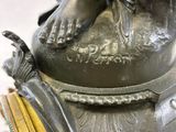 a statue of a woman holding a bird on top of a table