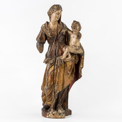 une statue en bois représentant une femme tenant un enfant