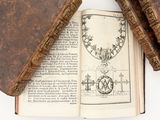 two old books sitting on top of an open book