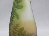 a glass vase with a green and yellow design on it