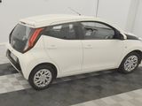 a picture of a small white car parked in a garage