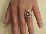 a woman sitting at a table with a ring on her finger