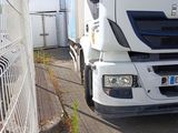 a white truck parked next to a fence on the side of the road