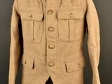 an old military jacket on a mannequin stand against a black background
