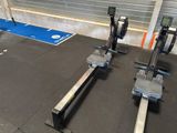 two machines that are sitting on the floor in the gym