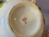 a white vase with a floral decoration on it
