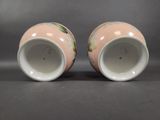 pair of pink and white vases with floral designs on them