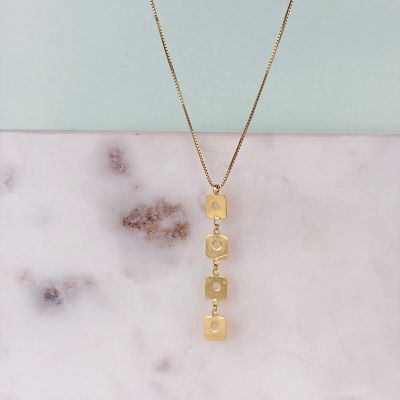 un collier plaqué or sur lequel est inscrit le mot « love »