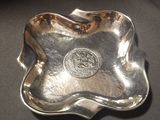 an image of a silver plate with a silver seal on it