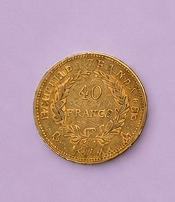 un gros plan d'une pièce d'or posée sur une surface violette