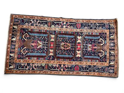 un tapis persan ancien, orné d'un motif bleu et rouge sur fond blanc