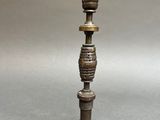 a metal candle holder with a metal base and a metal candle holder