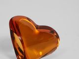a close up of a heart shaped glass object on a white surface
