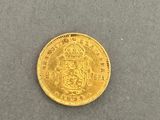 a gold sovereign coin on a gray surface