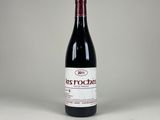 une bouteille de vin rouge posée sur une table blanche