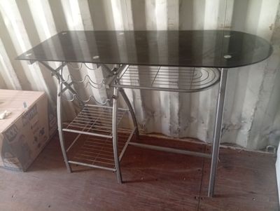 une table avec un plateau en verre et un piètement en métal